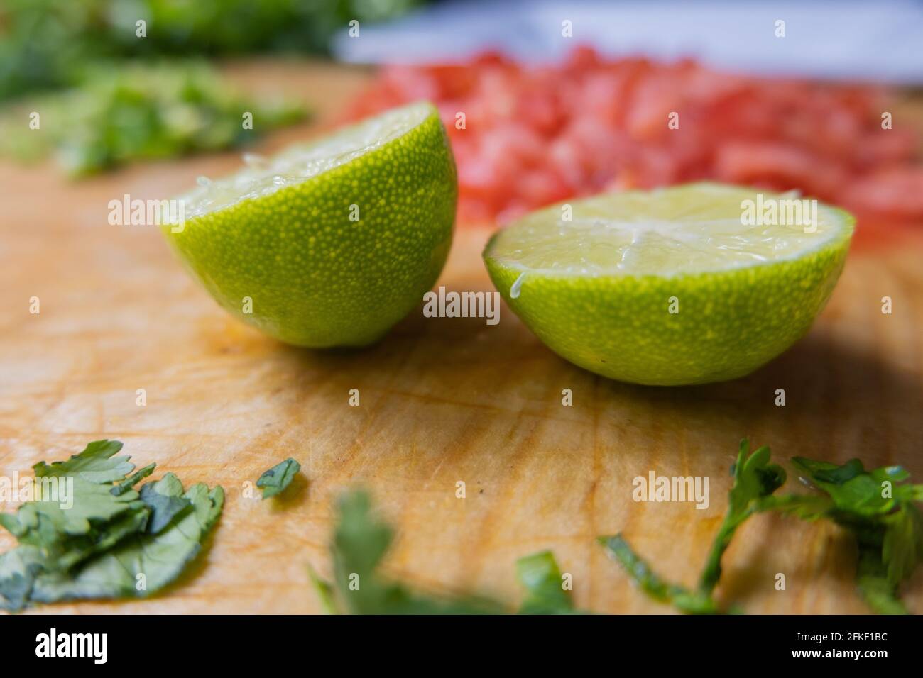 Affettato di calce su un tagliere con verdure tritate Foto Stock