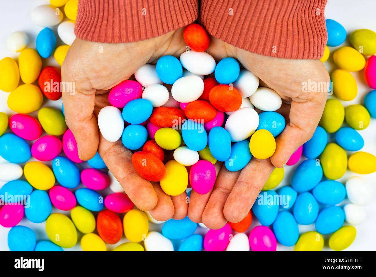 Caramelle colorate nelle mani della donna. EID Mubarak Foto Stock