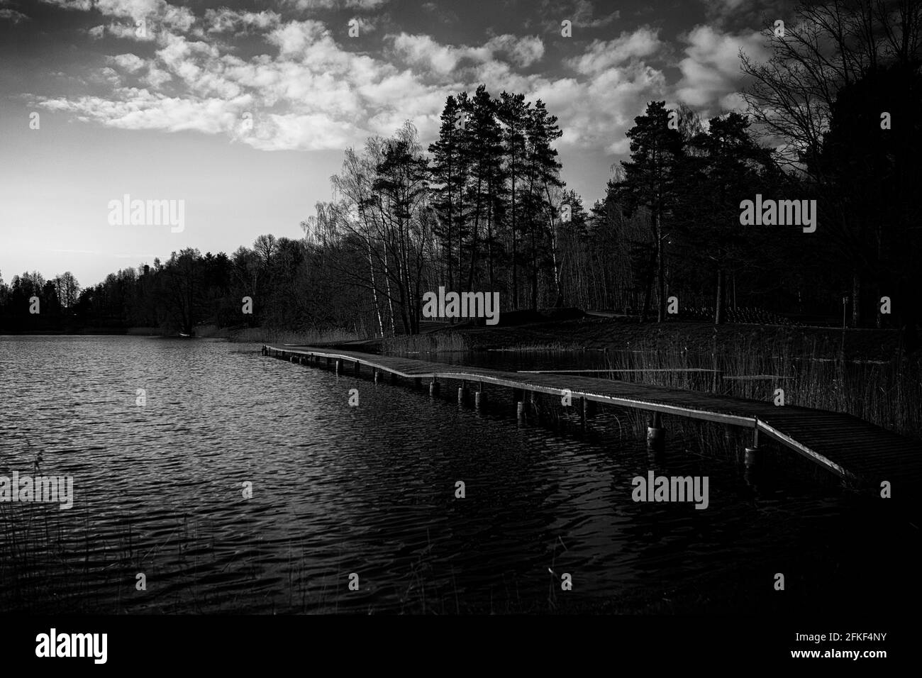 Il fiume nel parco. Passerella sul fiume. Percorso in legno croato sulla riva del fiume, bellissimo cielo nuvoloso Foto Stock