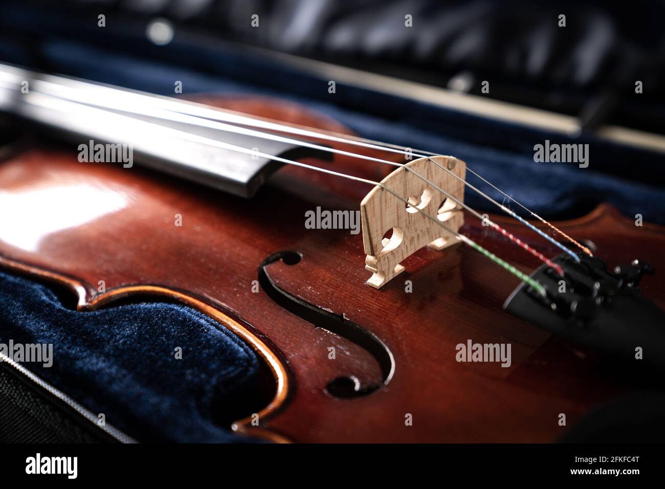 Un primo piano di un violino sinfonico contro un sfondo nero Foto Stock