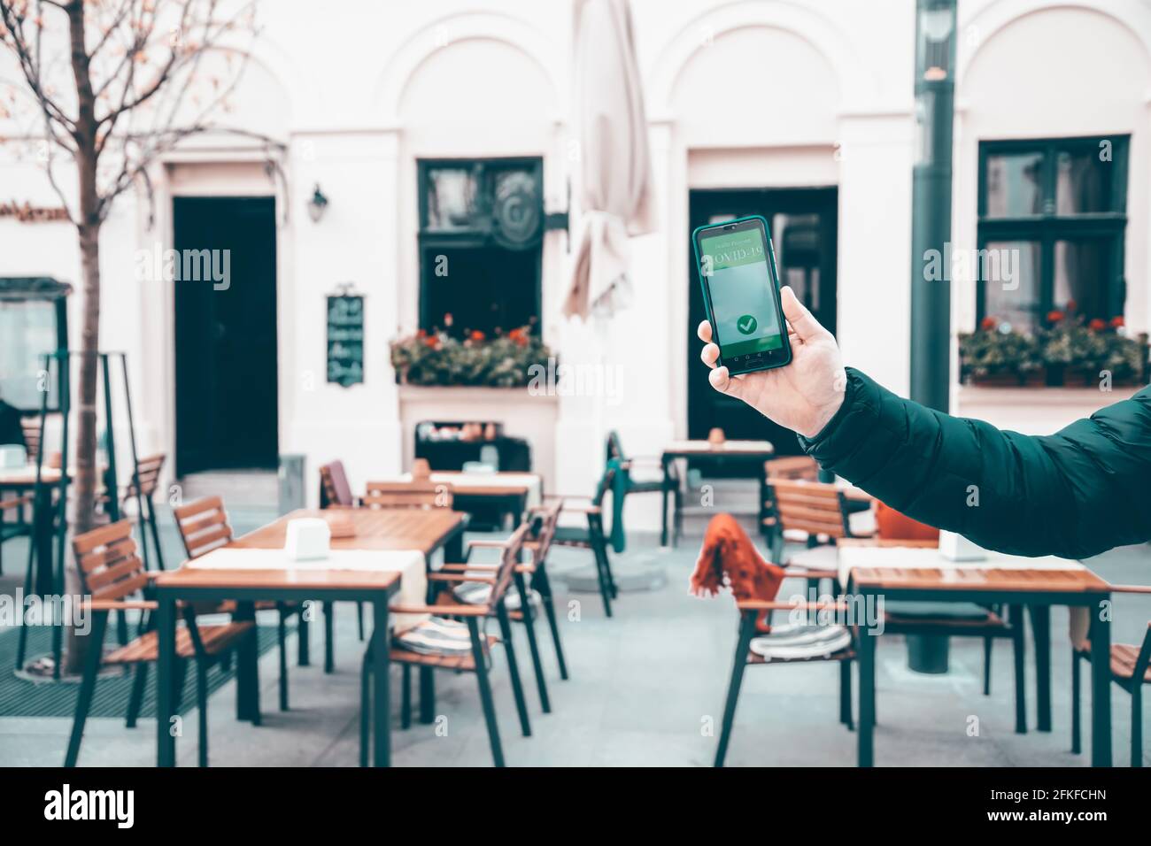 Vaccinato con certificato di immunizzazione su smartphone al ristorante o in terrazza. Foto Stock