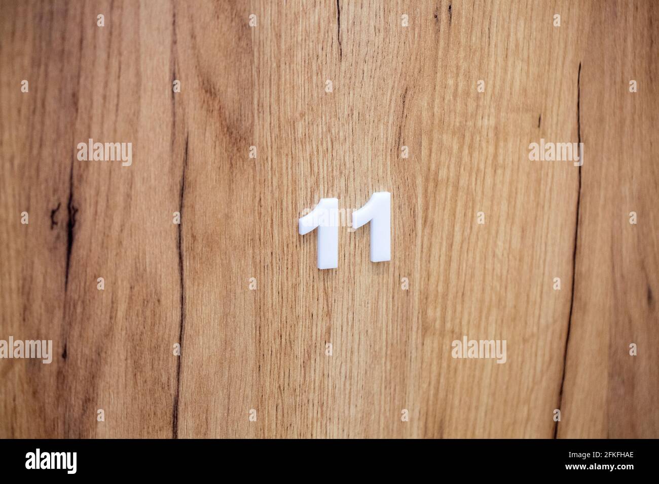 Porta in legno della camera in hotel con numero 11 Foto Stock