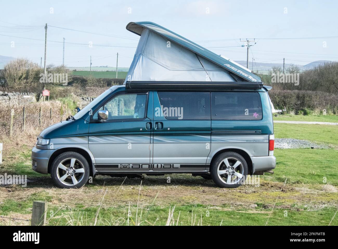 Mazda Bongo Friende con pop top, Auto Free Top tetto in un campo agricolo che è stato trasformato in un campeggio di base, sito di roulotte con gancio elettrico fino EHU. Situato vicino a Porth Neigwl, Hell's Mouth Beach, Penisola di Llyn. L'agricoltore beneficia di un reddito extra mentre campervan van vita popolare guadagno da un passo legale in su, soprattutto durante l'estate staycation quando è stato difficile trovare un sito con piazzole disponibili, soprattutto avendo EHU per ricaricare la batteria. Foto Stock