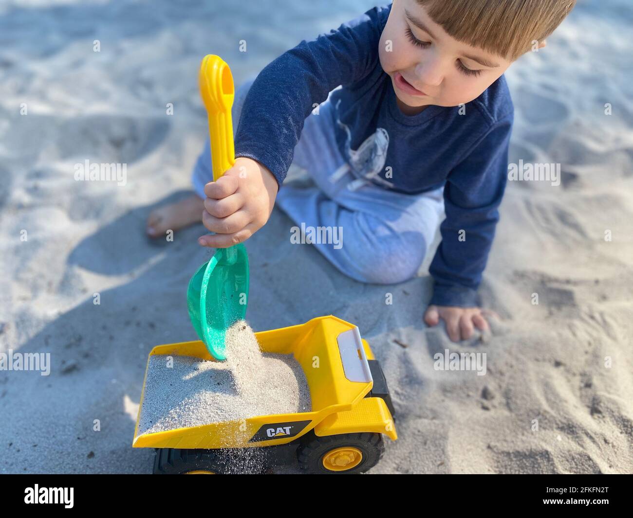 Little Boy giocando nella sabbia Foto Stock