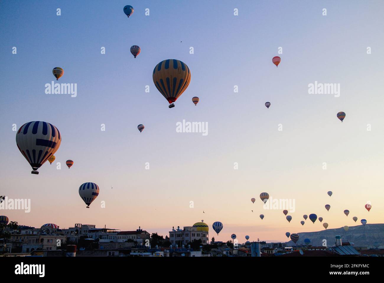 Volo in mongolfiera mentre il sole sorge in Cappadocia, Turchia. Foto Stock