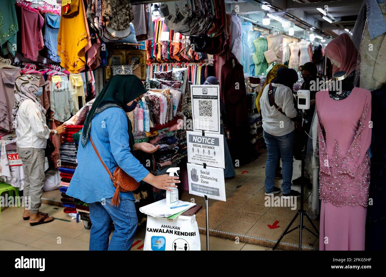 Kuala Lumpur, Malesia. 1 maggio 2021. Uno shopper musulmano che indossa un facemask come misura protettiva contro la diffusione del Covid-19 visto sanitizzare le sue mani prima di entrare in un negozio al bazar Ramadan durante il mese santo di Ramadan, in mezzo al coronavirus (Covid-19) scoppio. Credit: Wong Fok Loy/SOPA Images/ZUMA Wire/Alamy Live News Foto Stock