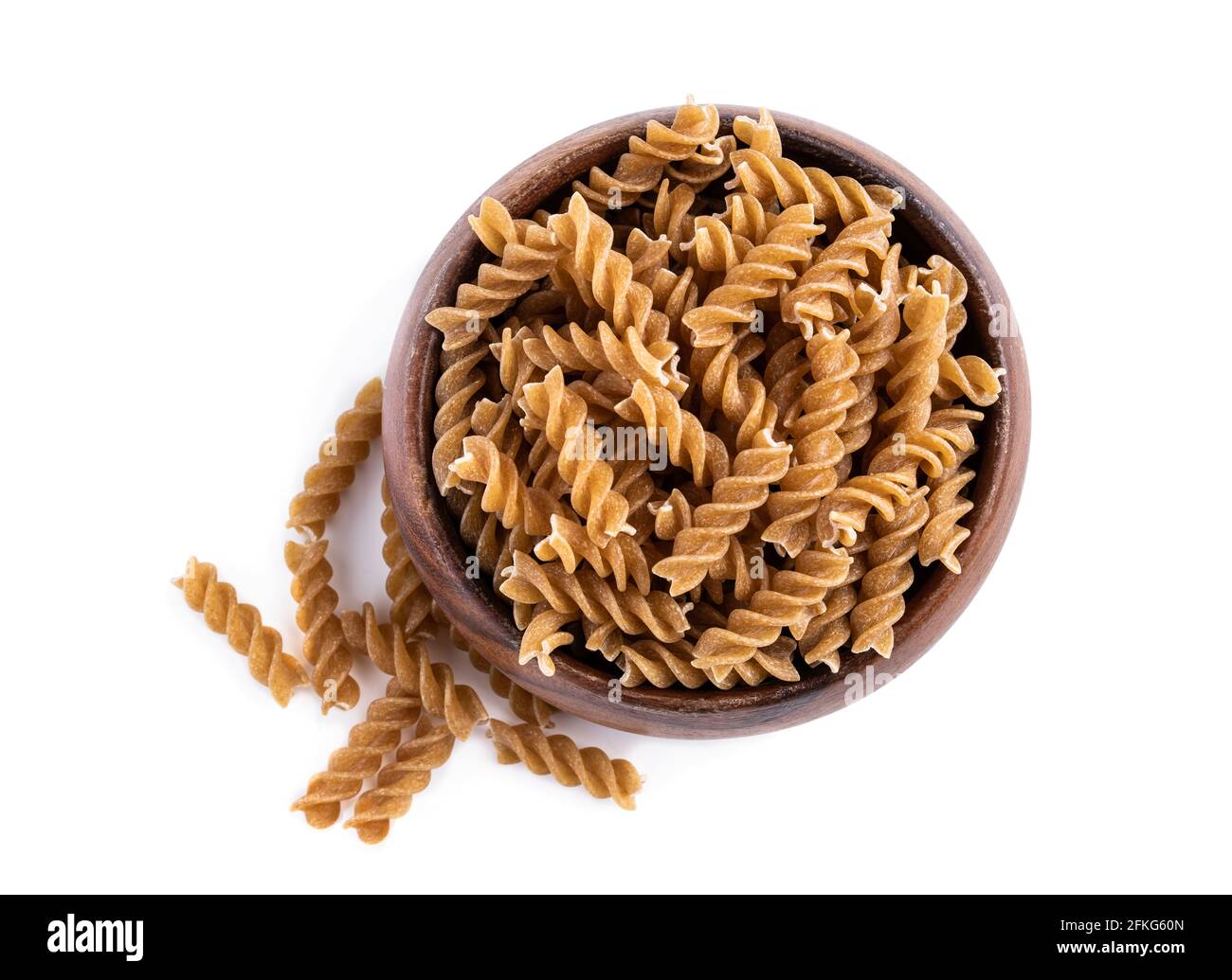 Fusilli di grano intero in ciotola di legno isolata su bianco Foto Stock