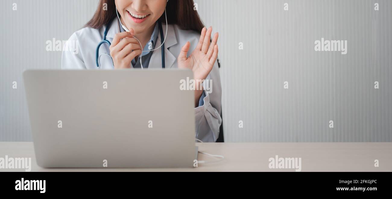 Il medico asiatico della donna è in linea che visita con un paziente sopra L'applicazione Internet e l'ascolto dei sintomi e spiega come trattare il d iniziale Foto Stock