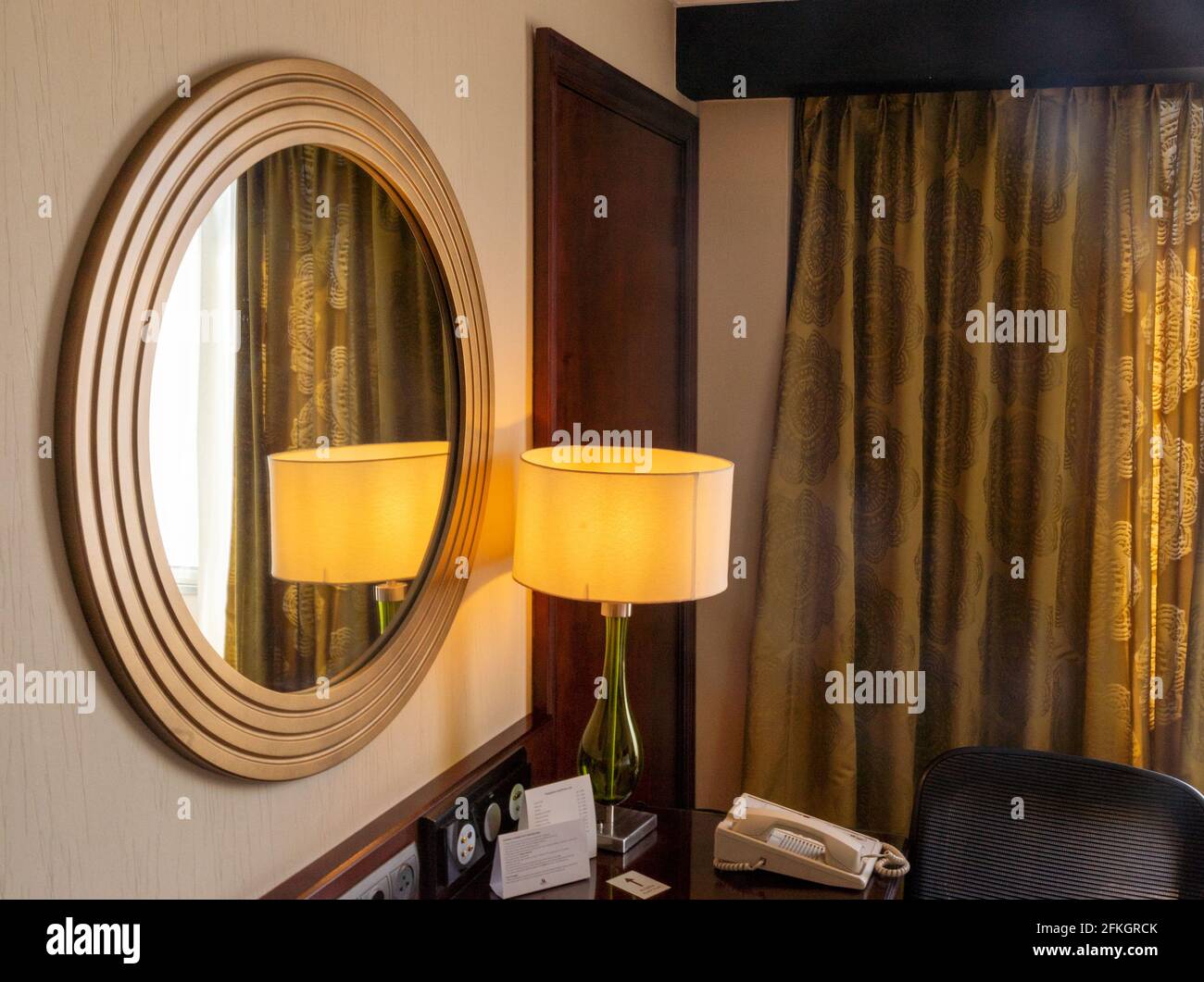 Frammento di interni di moderna camera d'albergo arabica con lampada, finestra, tavolo e telefono Foto Stock