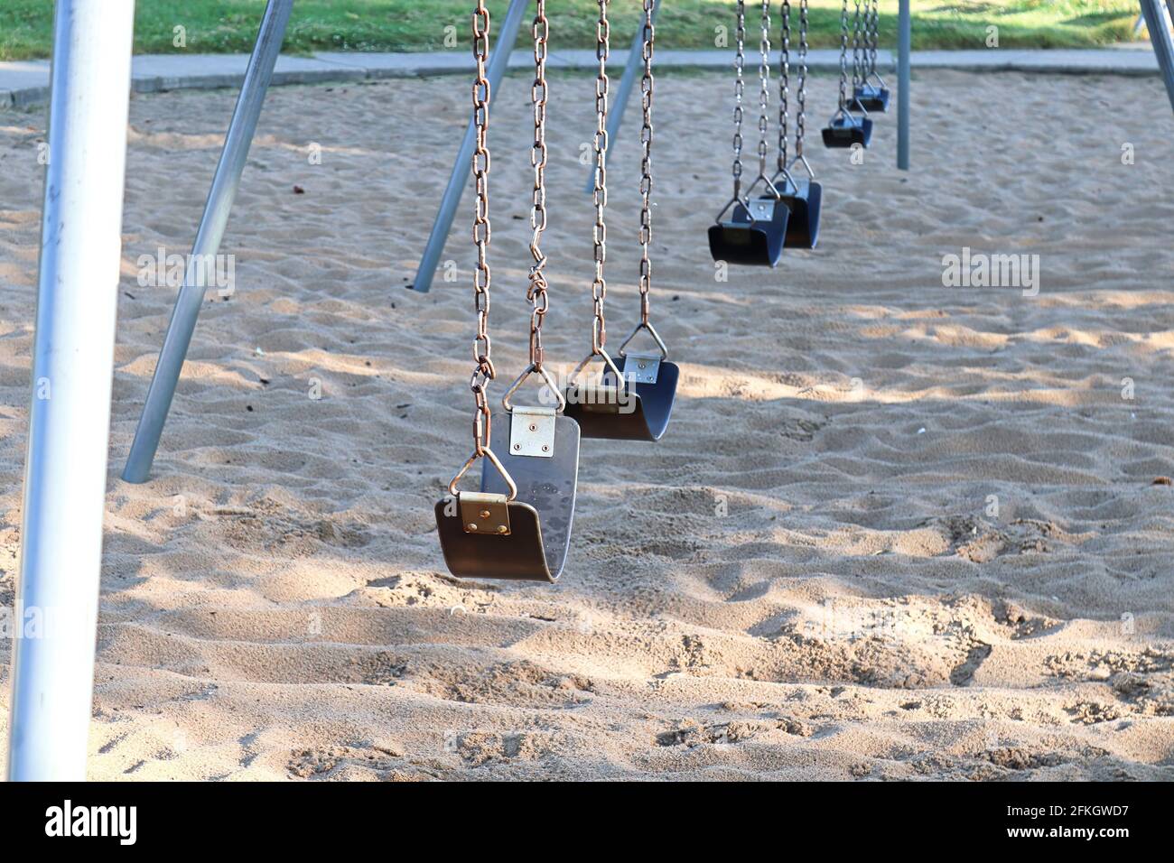 Posti a sedere su uno swingset al parco Foto Stock