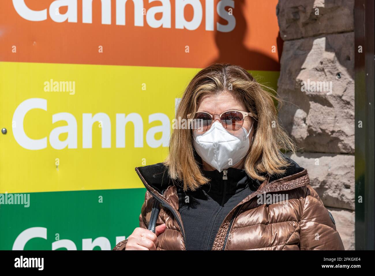 Donna latino-americana da un segno di un negozio di Cannabis in Yonge Street nel centro di Toronto, Canada Foto Stock