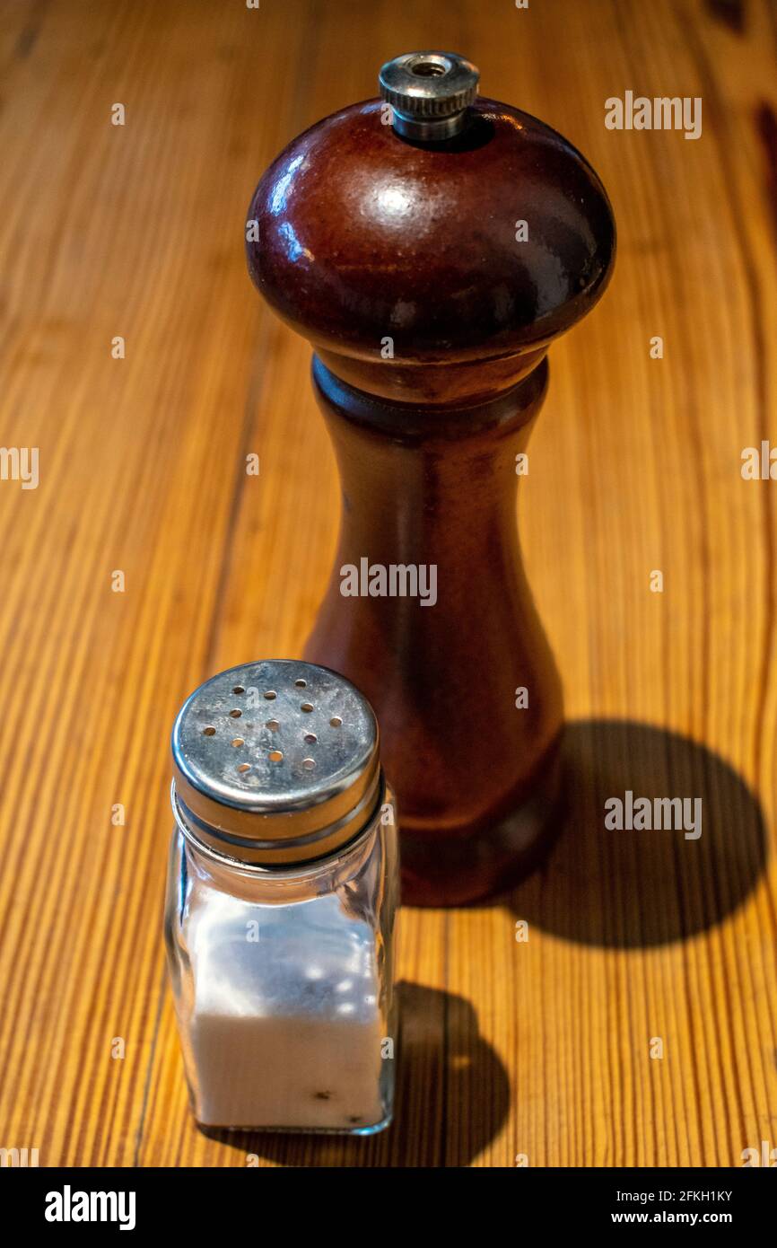 Agitatori per sale e pepe su tavolo di legno. Foto Stock