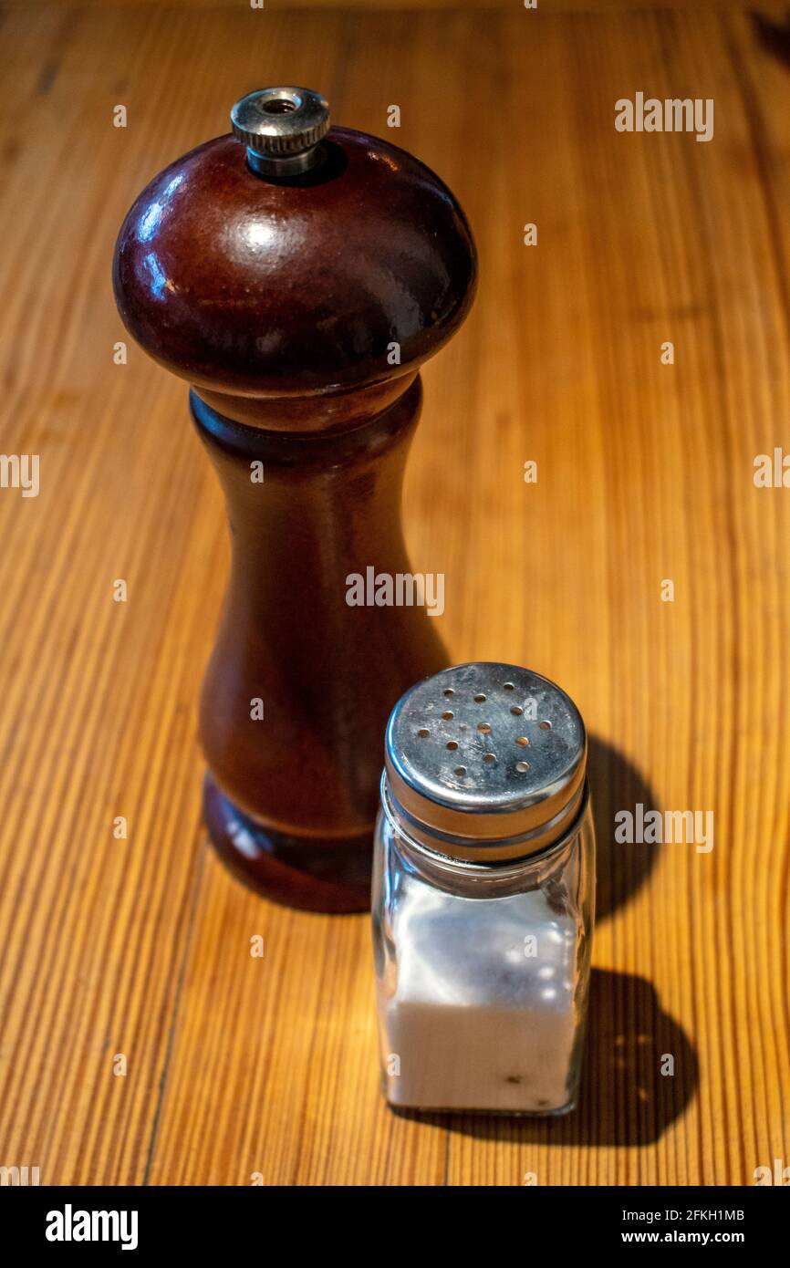 Agitatori per sale e pepe su tavolo di legno. Foto Stock