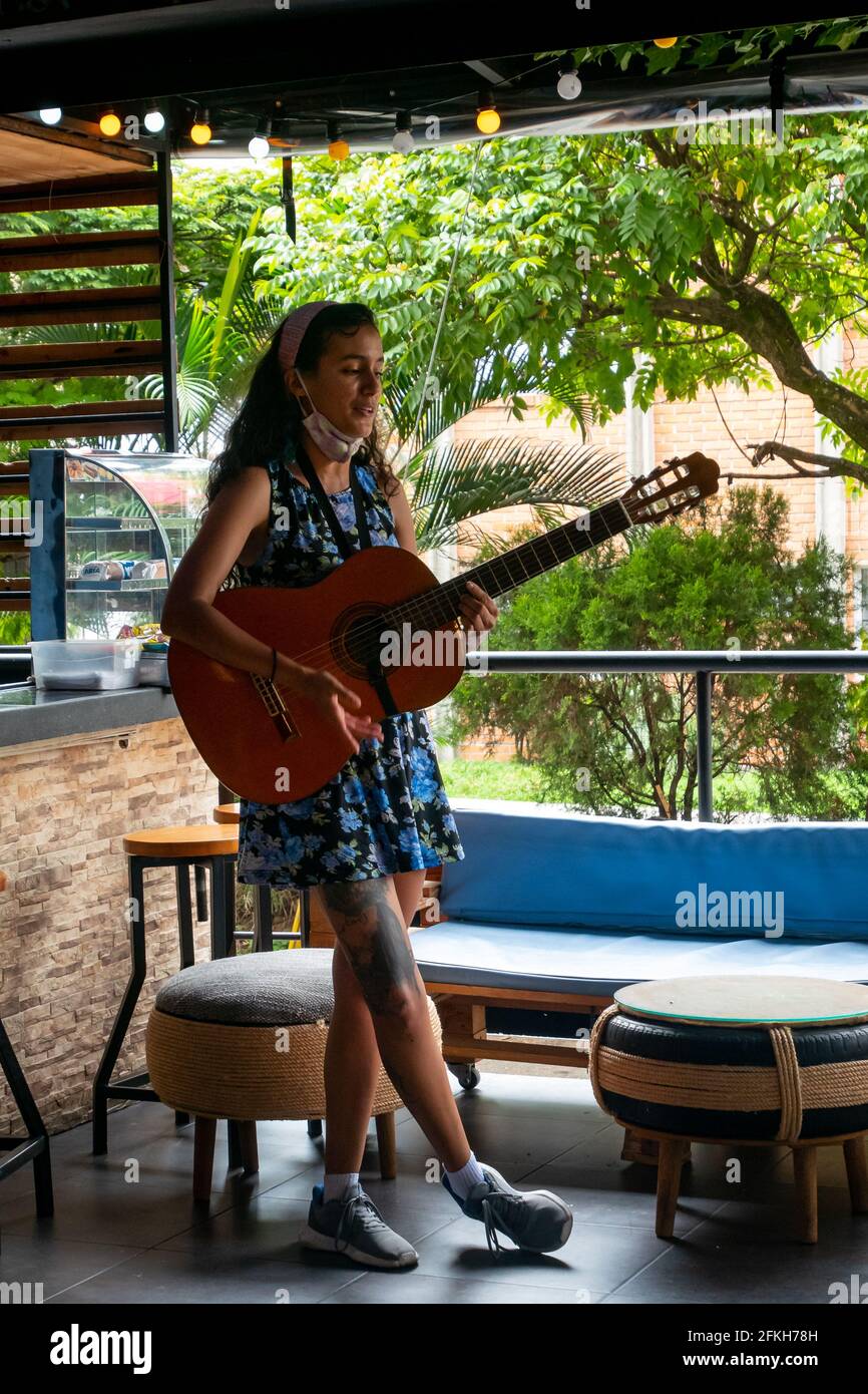 Medellin, Colombia - Marzo 28 2021: La Donna Latina sta cantando con la sua  chitarra in un ristorante Foto stock - Alamy