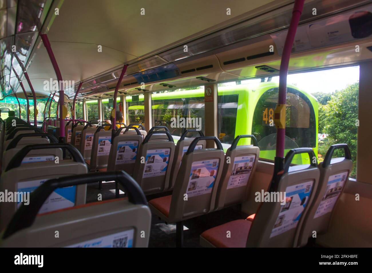 Un autobus a due piani di colore verde sulla destra sorprende l'autobus attuale sulla strada. Singapore Foto Stock
