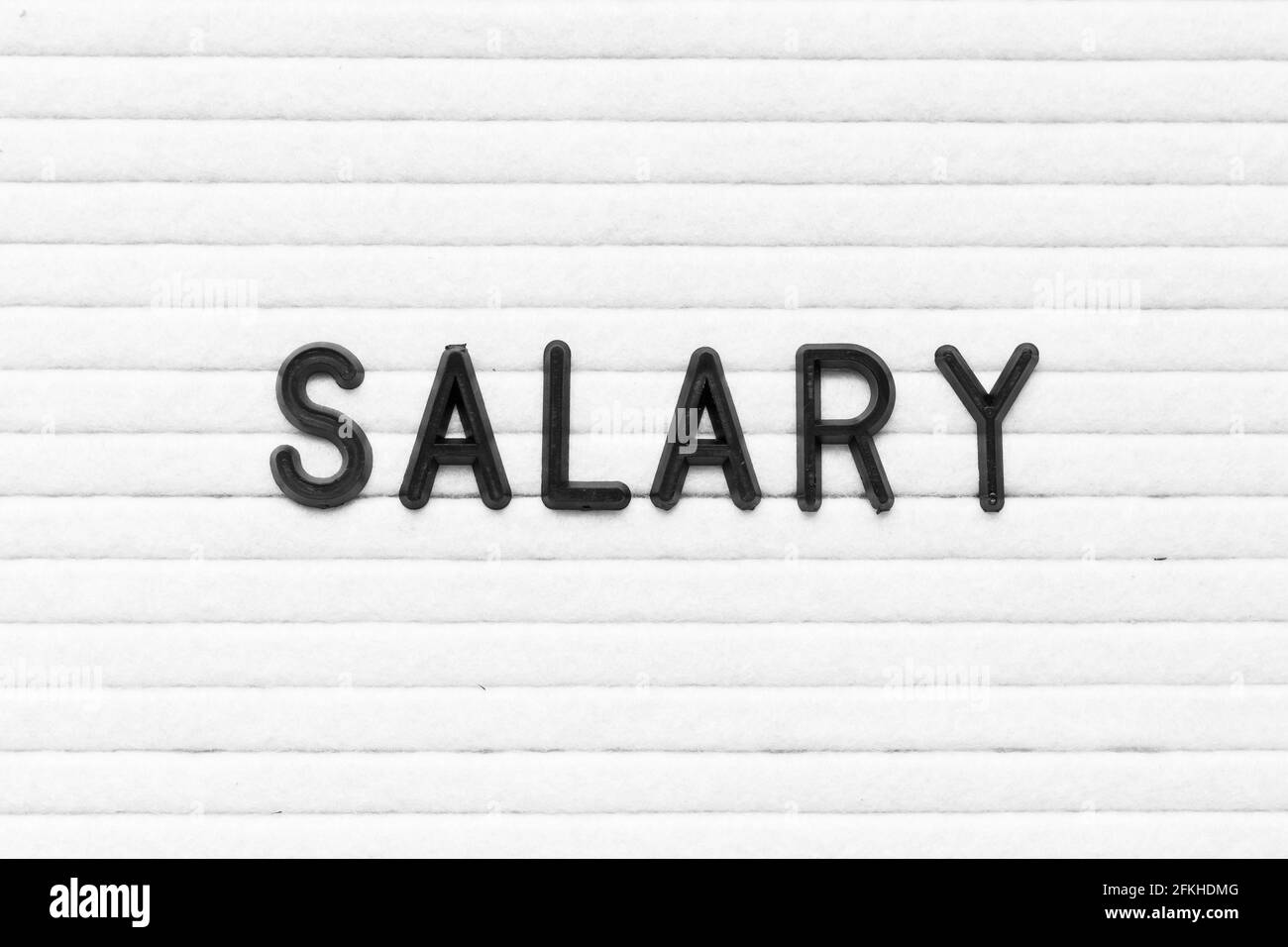 Lettera di colore nero nello stipendio delle parole sulla lavagna in feltro bianco sfondo Foto Stock