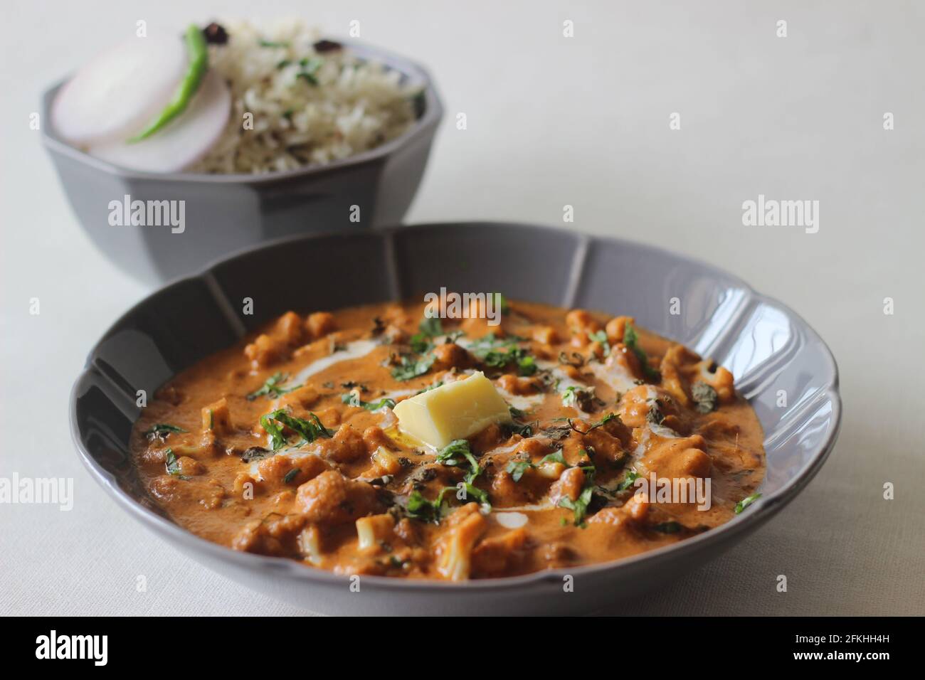 Cavolfiore arrosto con salsa di pomodoro e anacardi. Servito come contorno per il riso basmati aromatizzato al cumino. Popolare combinazione di pasti dal nord dell'India po Foto Stock