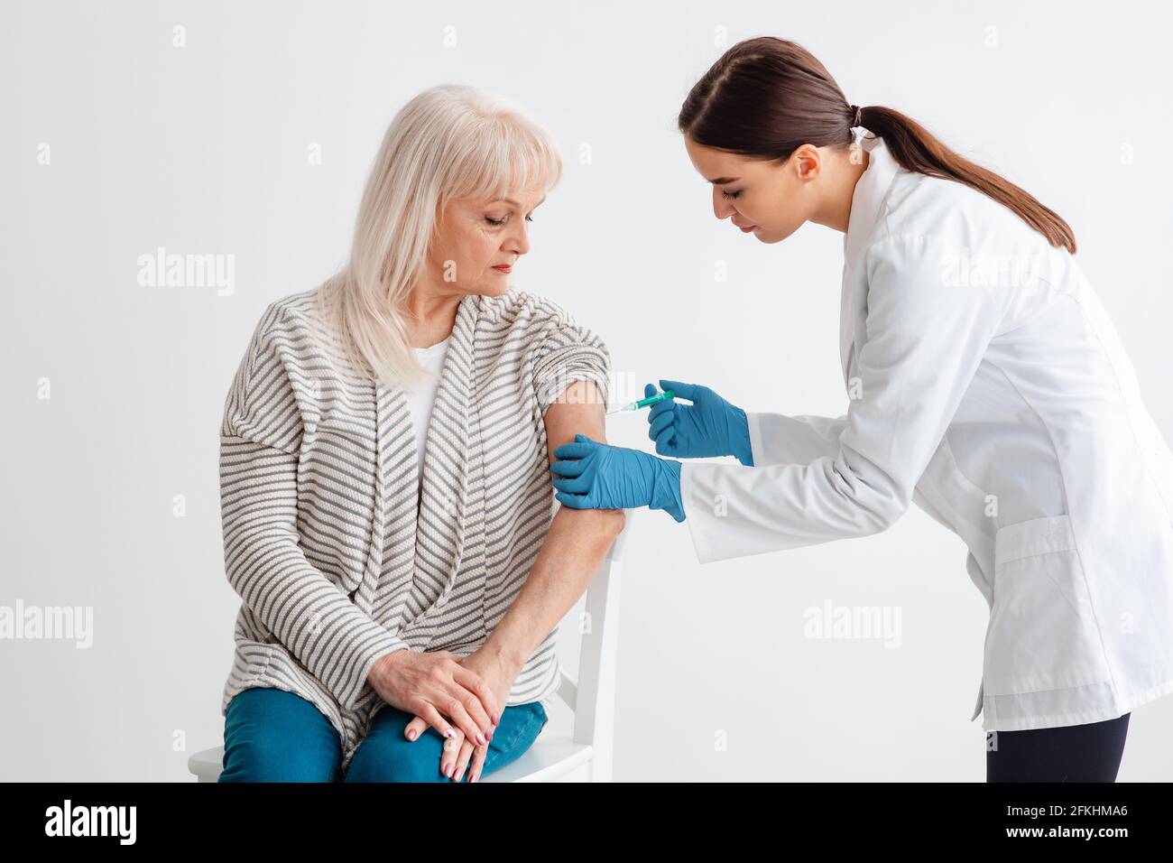 Senior Lady che riceve il vaccino di Coronavirus per iniezione intramuscolare Foto Stock