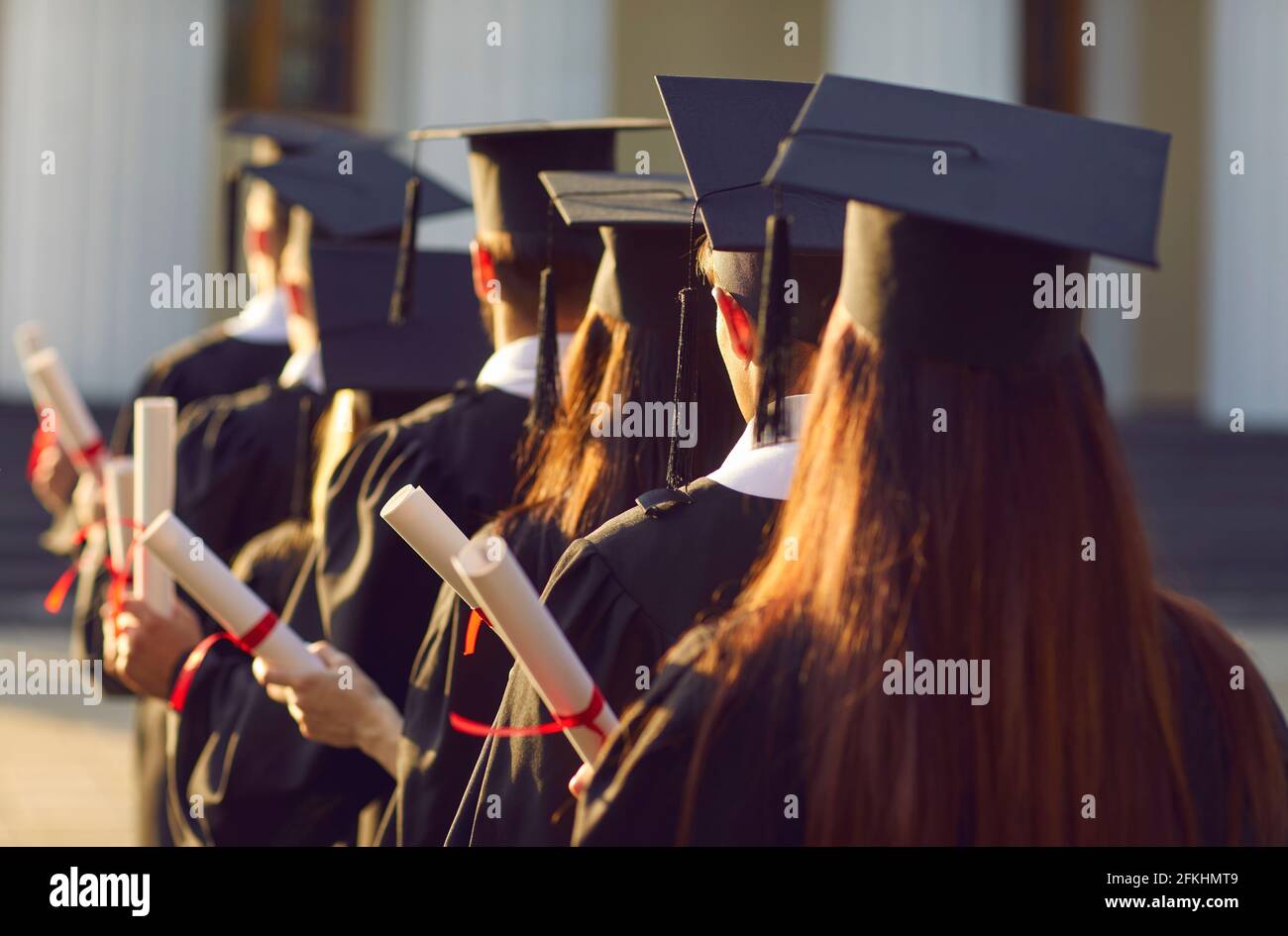 Laurea di gruppo. I laureati dell'università tengono il premio di laurea in graduation cerimonia vista posteriore Foto Stock