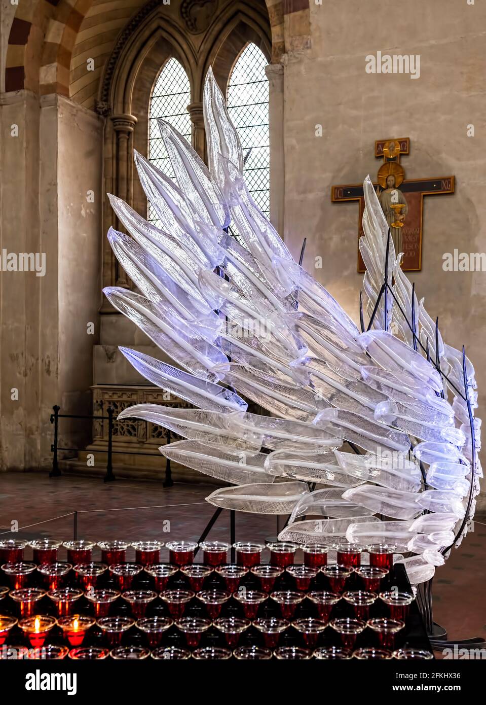 Angel Wings Solace scultura in vetro Covid 19 Memorial St. Albans Cathedral, Herts UK - Angelo singolo ala in vetro con candele rosse di preghiera in primo piano Foto Stock