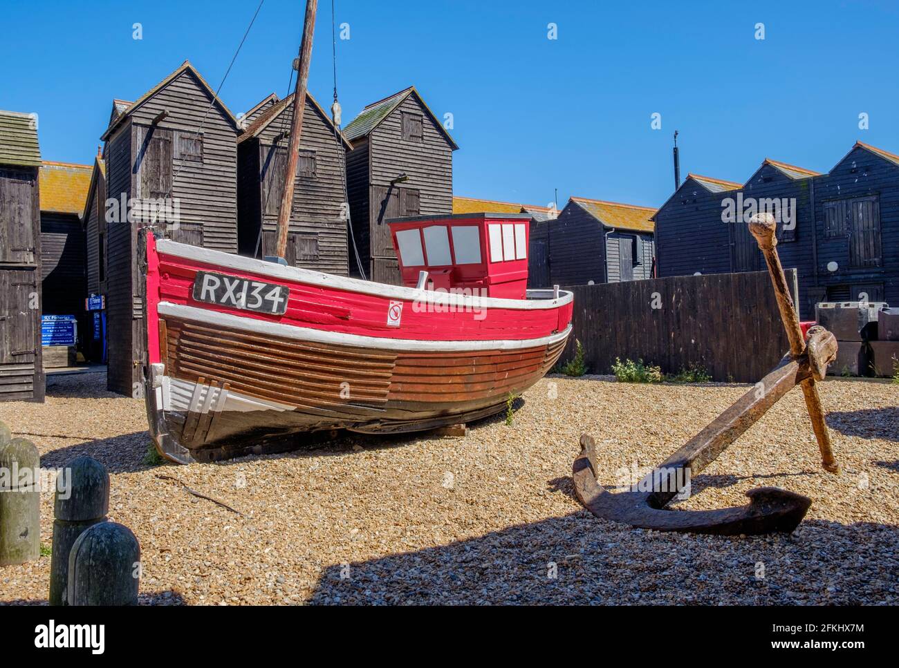 Idea di staycation. Vecchia barca di legno da pesca in camicia allo Stade, Hastings, East Sussex, con Net Shops in background. Inghilterra, Regno Unito Foto Stock