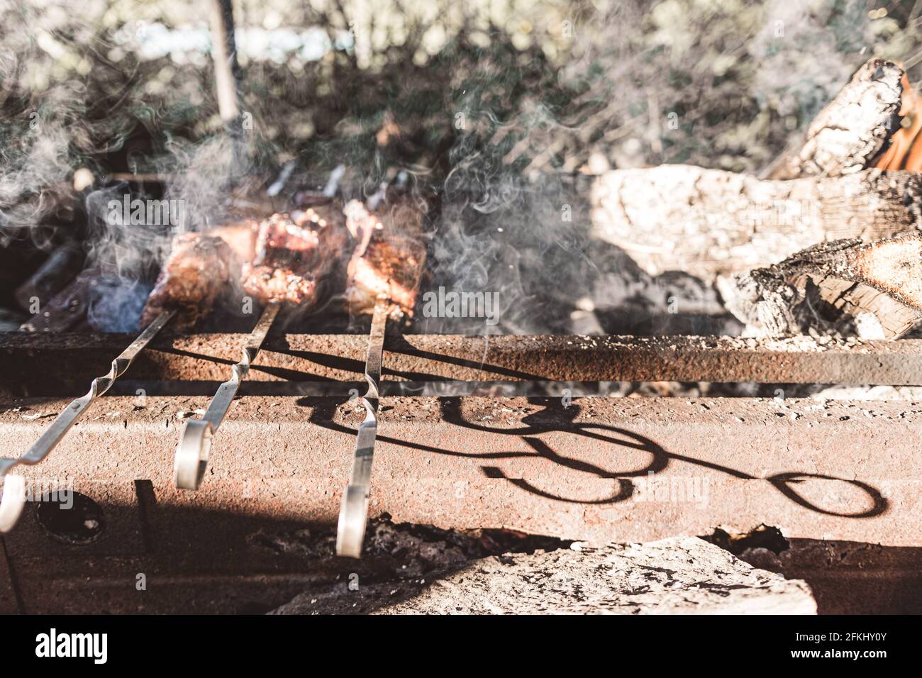 Carne alla griglia. Barbecue mattutino. Cucina barbecue sulla griglia con fumo. Cuocere la carne fresca marinata con cipolle. Barbecue marinato alla griglia Foto Stock