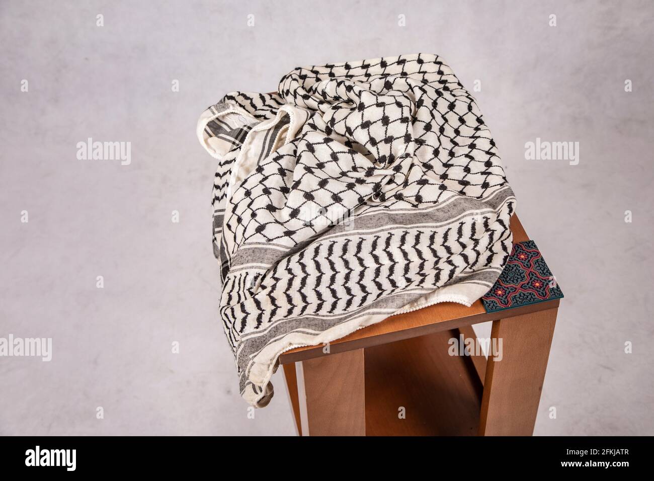 Sciarpa tradizionale palestinese di Keffiyeh su tavolo di legno Foto Stock