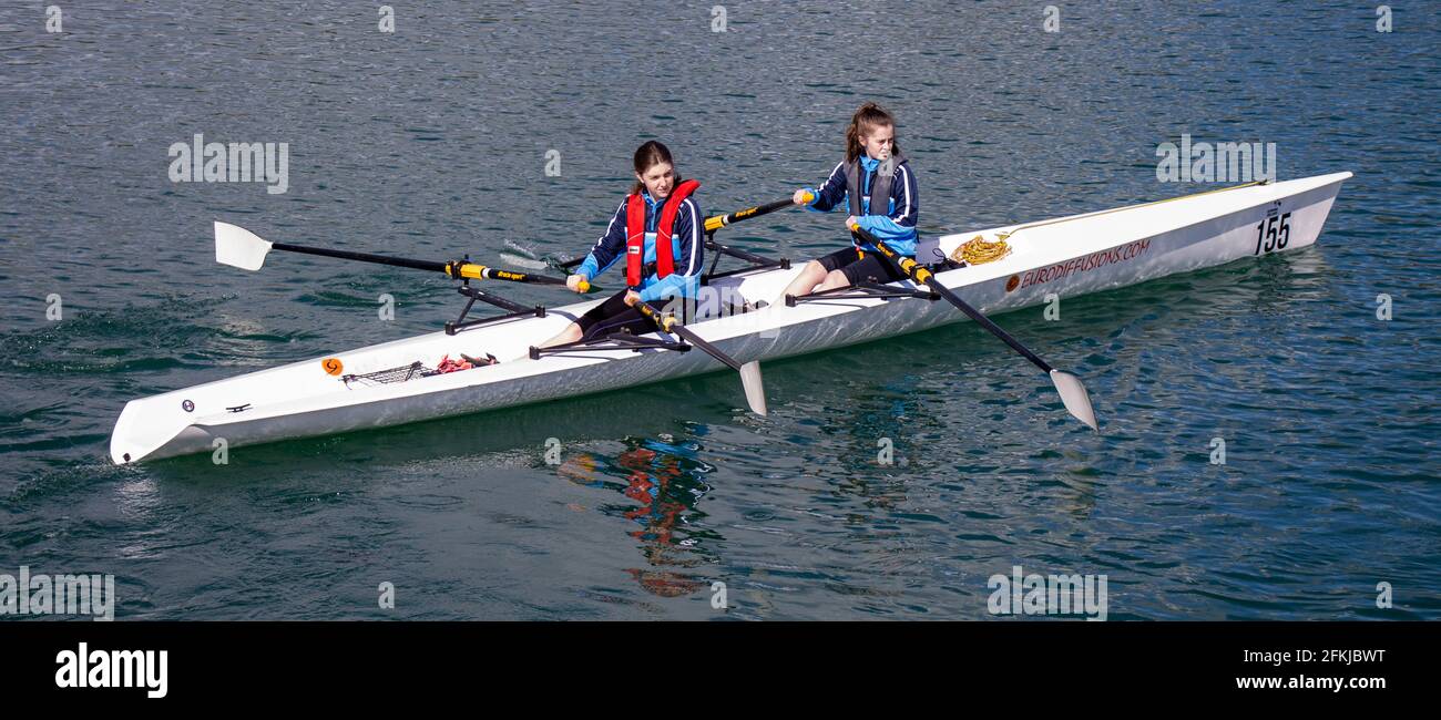 2 ragazze giovani imparano a filare o a sculare una barca Foto Stock