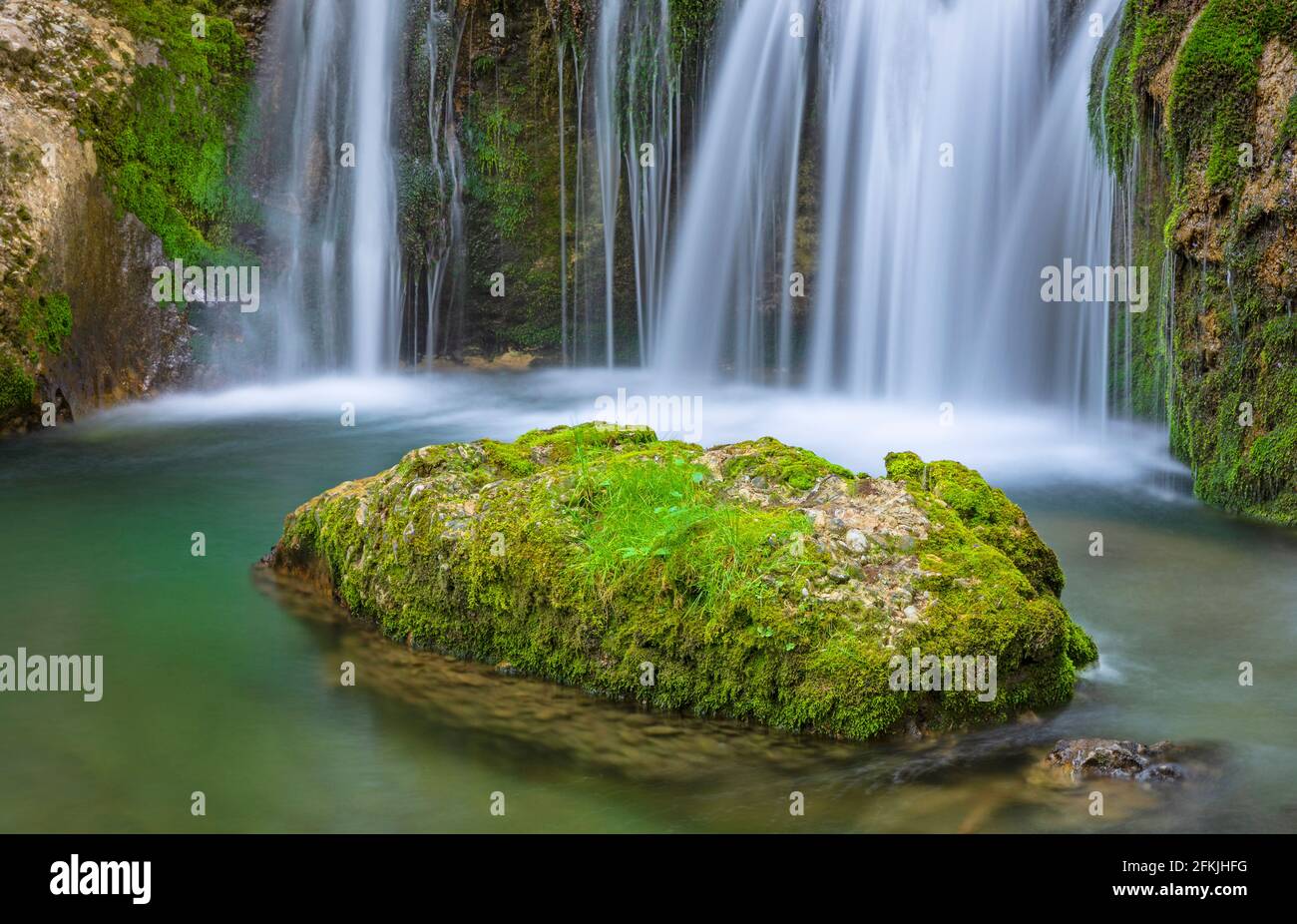 Primo piano di una piccola cascata con rocce e muschio verde. Allgäu, Baviera, Germania Foto Stock