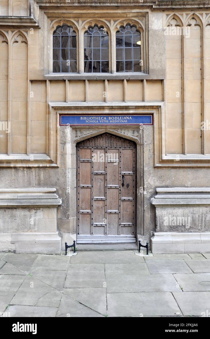 Vista della facciata in stile gotico inglese con una vecchia porta in legno all'interno del cortile della Biblioteca Bodleian Vecchia, Oxford, Regno Unito. Foto Stock