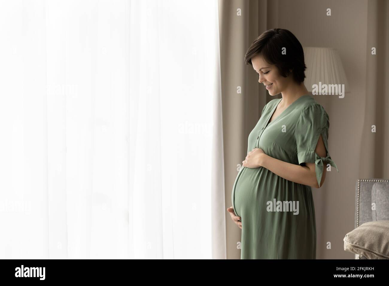 Felice giovane donna incinta toccare la pancia carezza Foto Stock