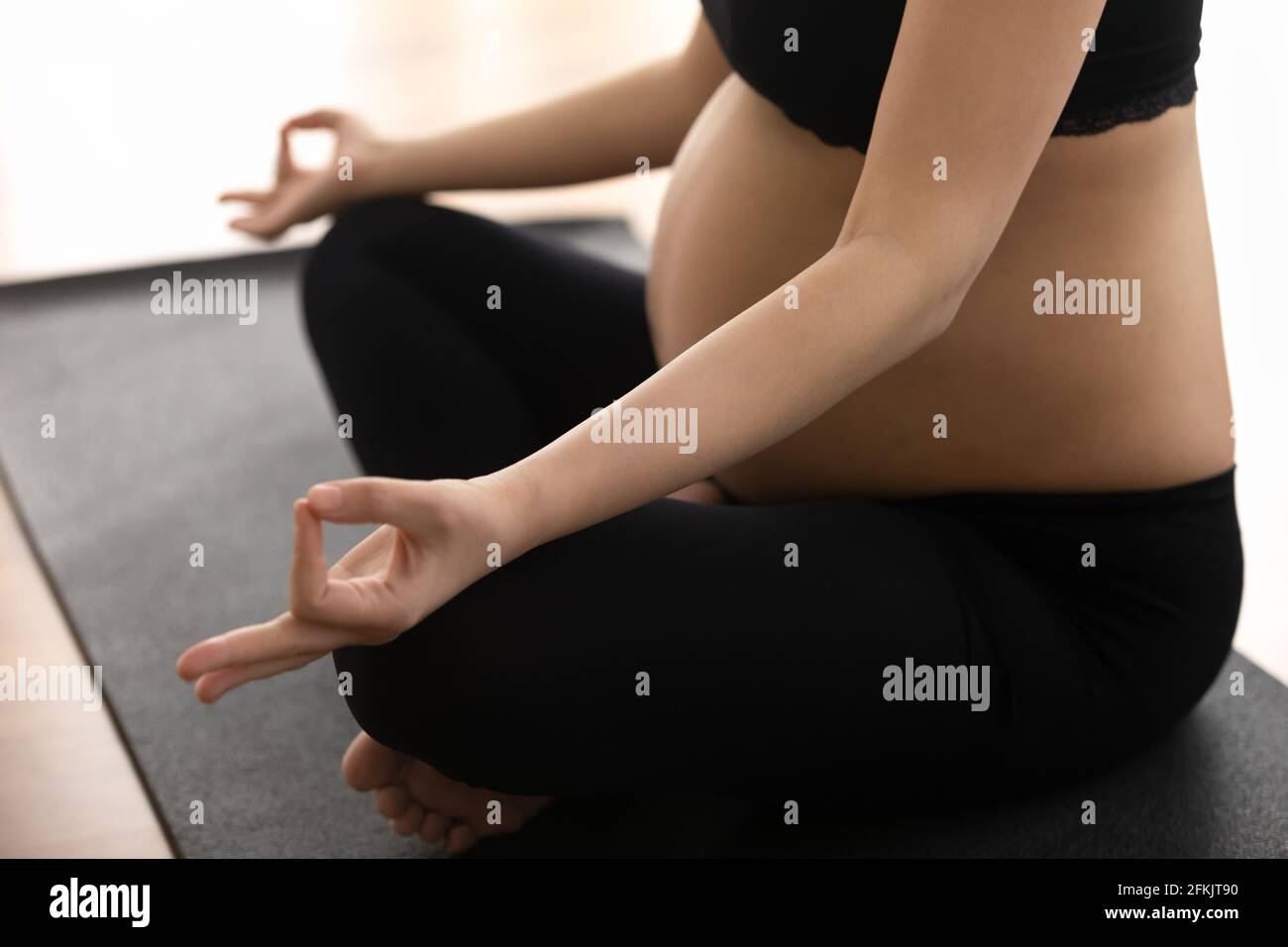 Primo piano di pratica yoga donna incinta Foto Stock