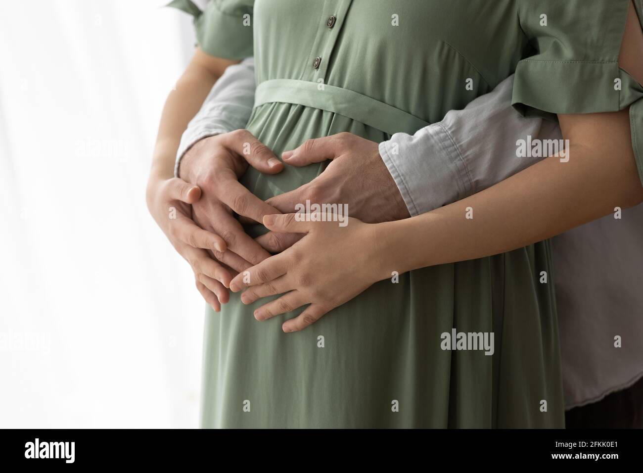 Primo piano di coppia futuri genitori toccare baby bump Foto Stock