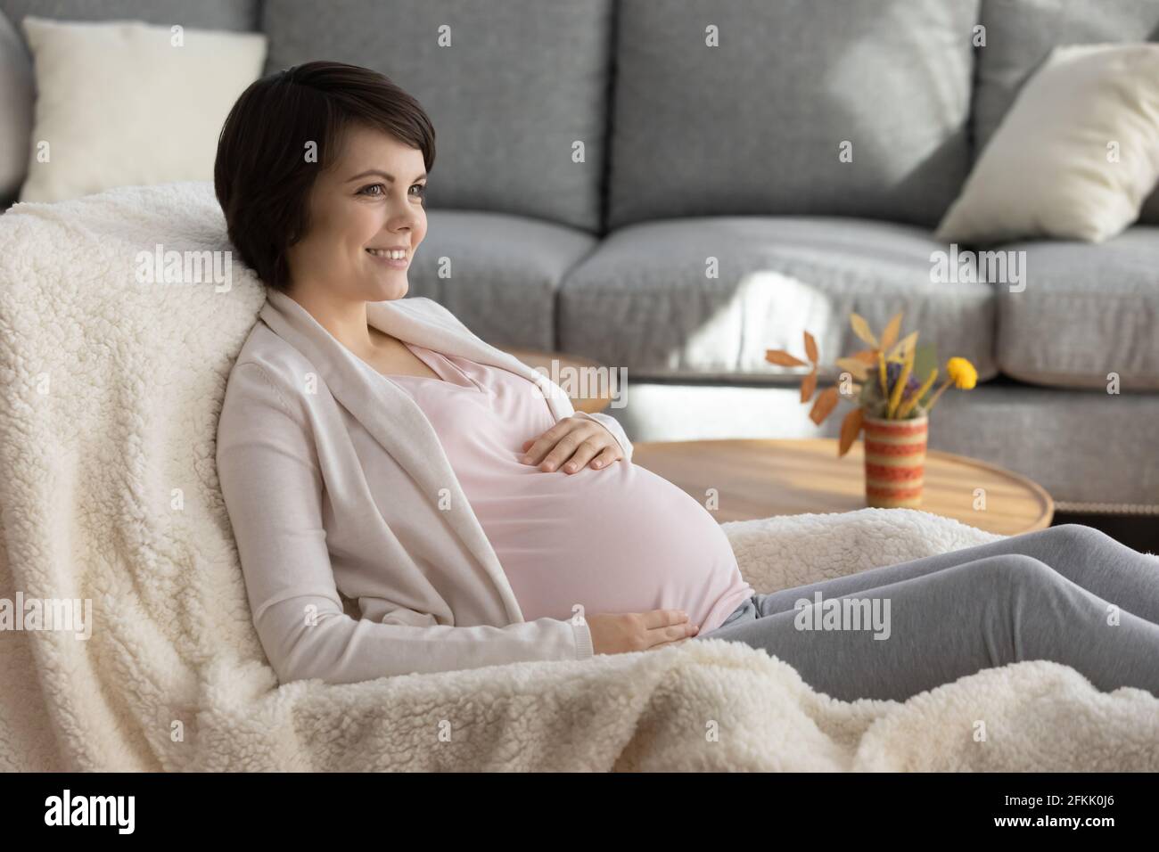 Sorridente giovane donna incinta sogno di felice maternità Foto Stock