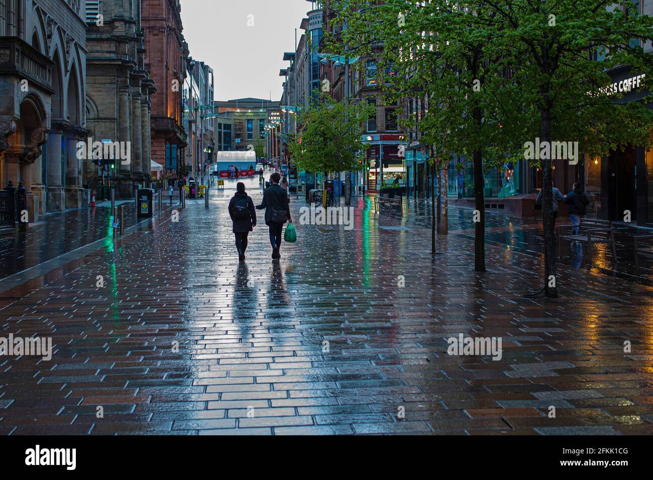 Le coppie camminano in una via vuota dello shopping nel centro di Buchan Street, Glasgow, Scozia, Regno Unito Foto Stock