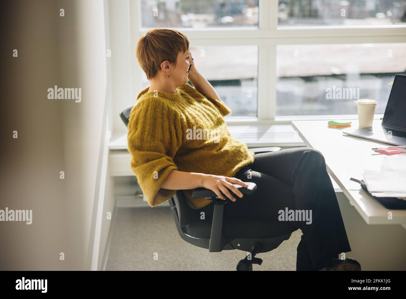 donna d'affari che lavora in ufficio e fa una telefonata. Dirigente donna che parla al telefono seduto alla sua scrivania. Foto Stock