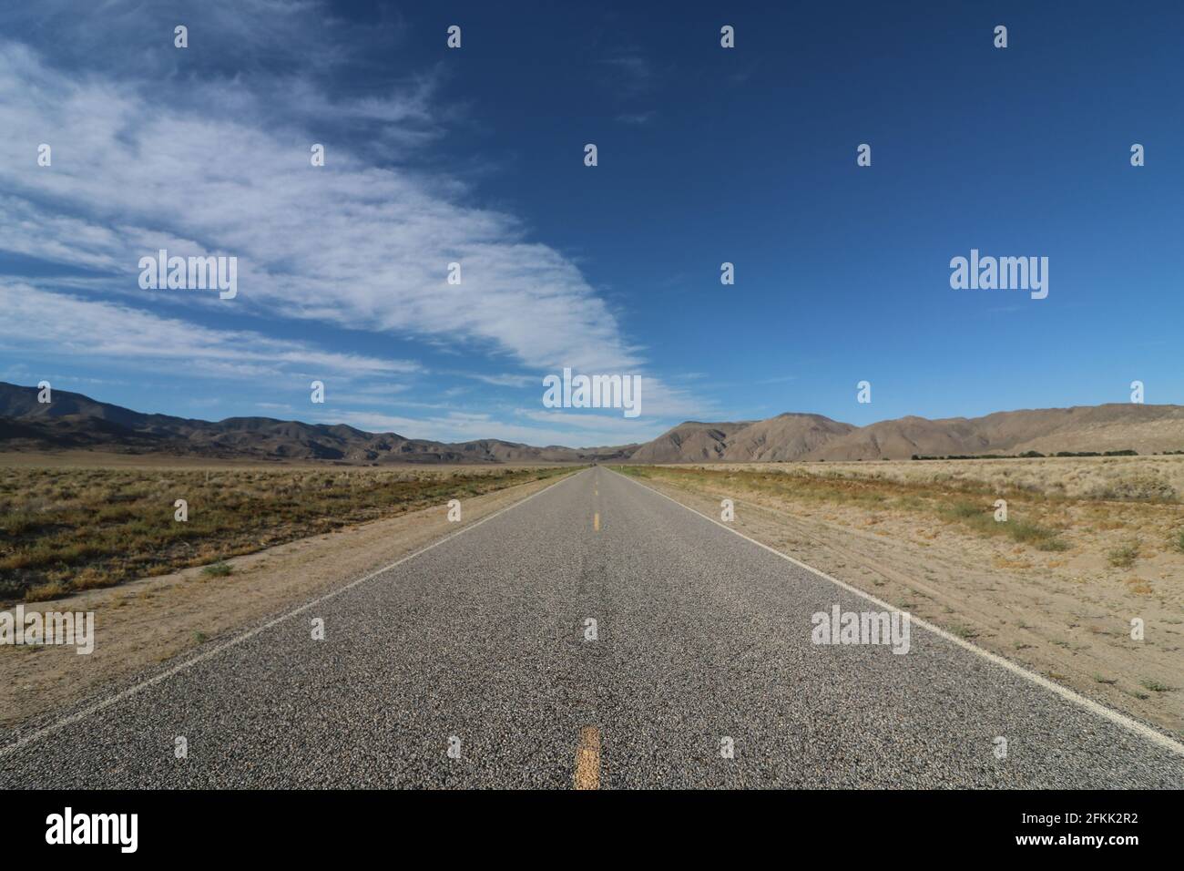 Mezzo della desolata autostrada che attraversa il Parco Nazionale della Death Valley, viaggiando a Las Vegas, Nevada Foto Stock