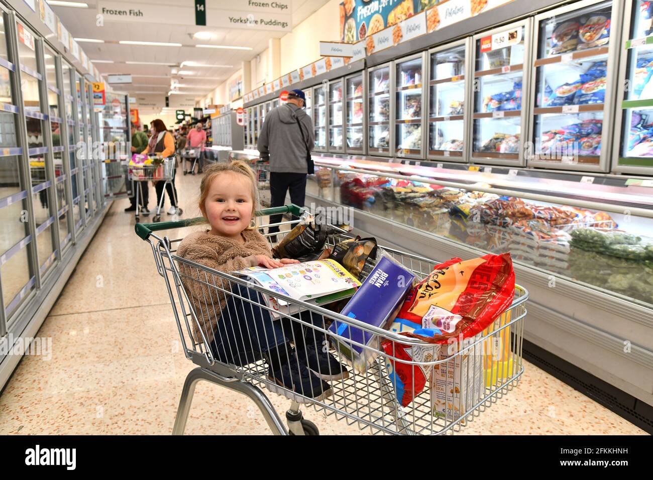 Felice sorridente bambino shopping in Morrisons supermercato Gran Bretagna, madre Regno Unito bambini ragazze Foto Stock