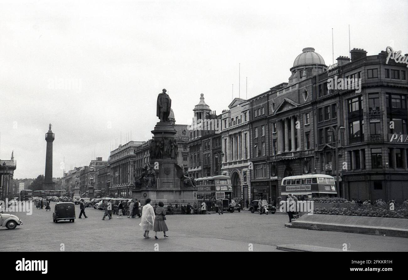 1950, storica, Dublino, Irlanda, una vista lungo o'Connell Street che mostra in primo piano il memoriale di Daniel o'Connell, un leader nazionalista irlandese del XIX secolo, di cui la strada fu chiamata nel 1924. Attività generale e nella foto si può vedere un paio di autobus a due piani. Foto Stock