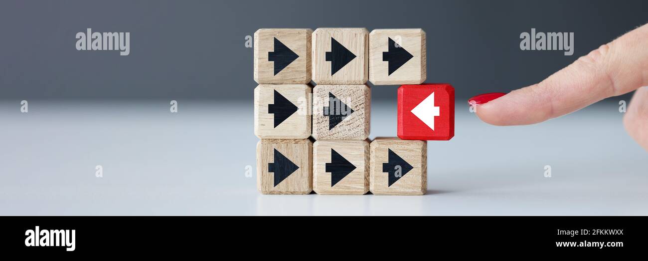 Cubetti di legno con frecce nere e uno rosso Foto Stock