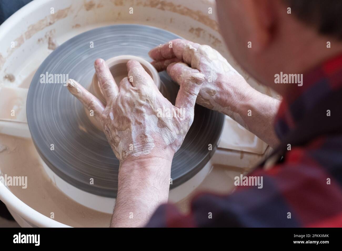Ruota di vasaio e mani di artigiano che fanno una caraffa Foto Stock