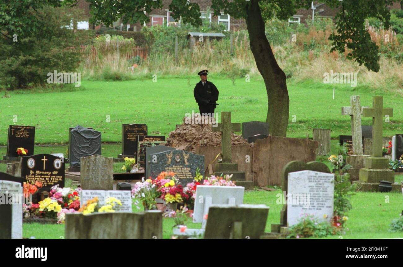Dr. Harold Shipman omicidi ottobre 1998A poliziotto ad Hyde Cimitero a guardia della zona un corpo è stato esumato in anticipo Ore del mattino è in piedi dietro il tumulo Di terra rimosso dalla tomba Dr Harold Shipman è accusato di aver ucciso 15 dei suoi paitents Foto Stock