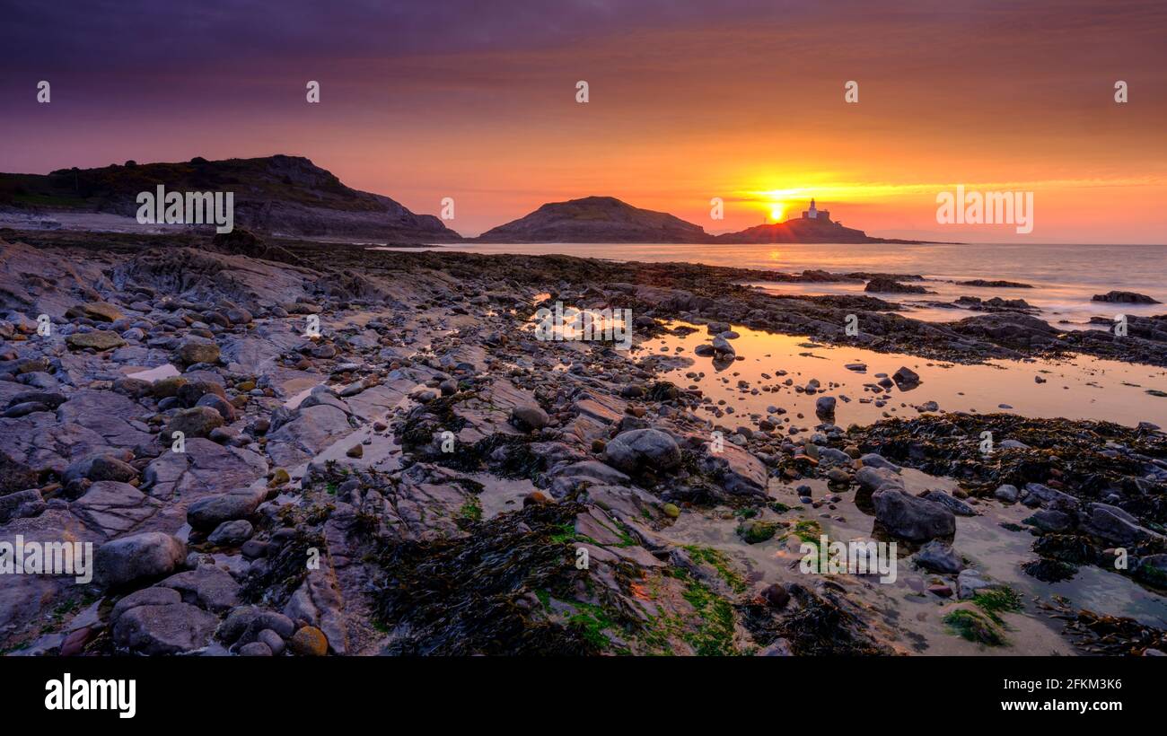 Mumbles, Regno Unito - 21 aprile 2021: Alba sulla Mumbles Light House e le rocce di Bracelet Bay vicino a Swansea, Galles, Regno Unito Foto Stock