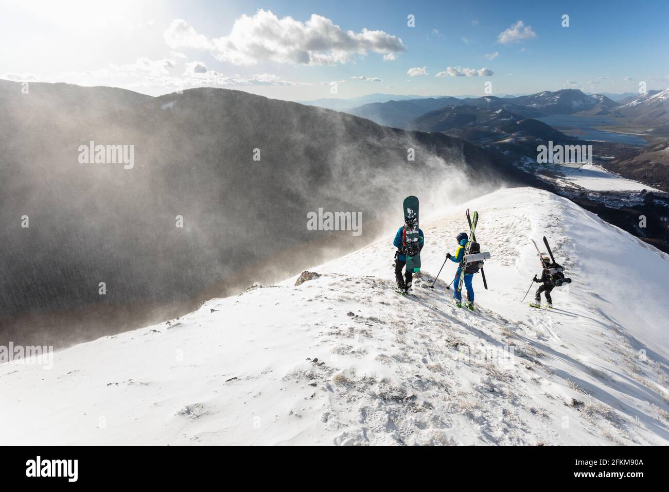 Sciatori che guardano la polvere di neve formata dal vento Foto Stock