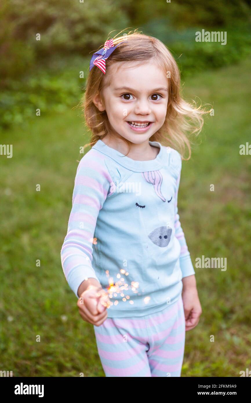 Girl Holding Sparkler il 4 luglio Foto Stock