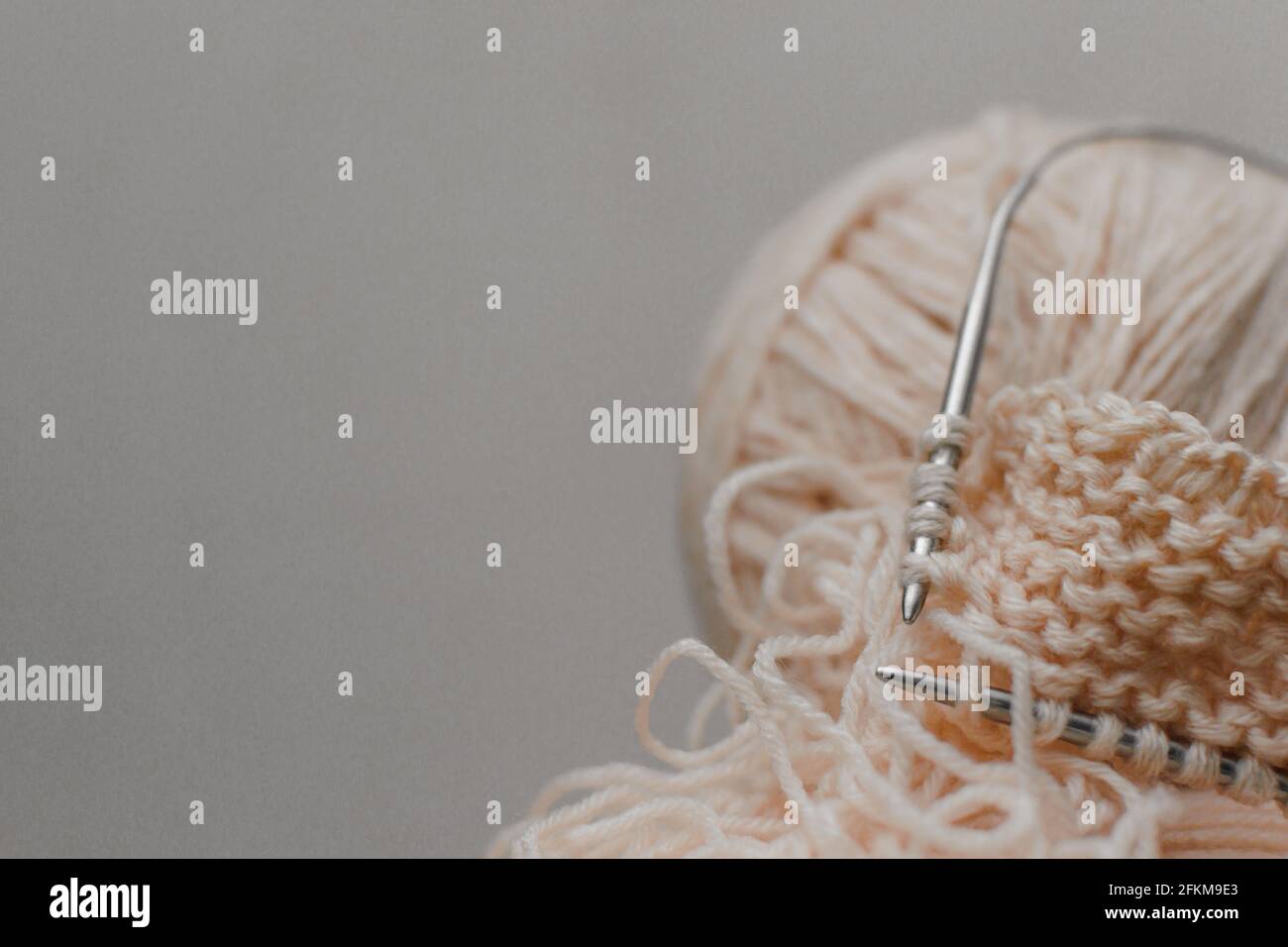 Palla di filo di carne per aghi da maglieria e da maglieria, fondo grigio. Foto Stock