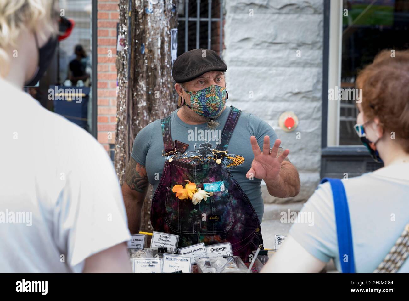 Seattle, Washington, Stati Uniti. 2 maggio 2021. Bliss with Blissful Wunders i cioccolatini della pasticceria parlano con i clienti al mercato agricolo di Ballard a Seattle. Questa settimana, il Washington state Health Department ha annunciato che più di una dozzina di contee rischiano di tornare alla fase 2 del piano di riapertura dello stato a causa dell'aumento dei casi e delle ospedalizzazioni COVID-19. Credit: Paul Christian Gordon/Alamy Live News Foto Stock