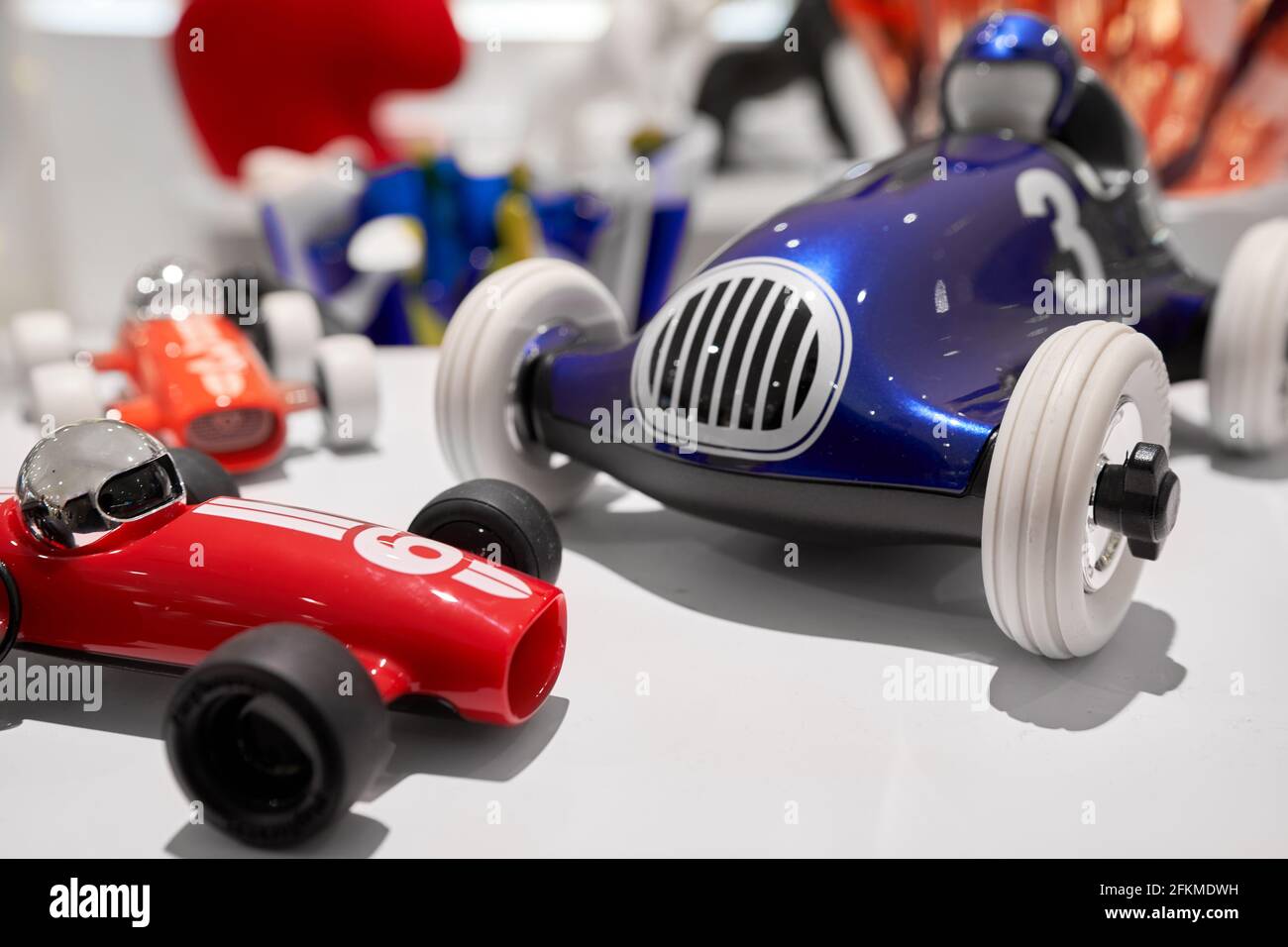 Auto da corsa blu e rossa, auto giocattolo vintage su superficie bianca Foto Stock