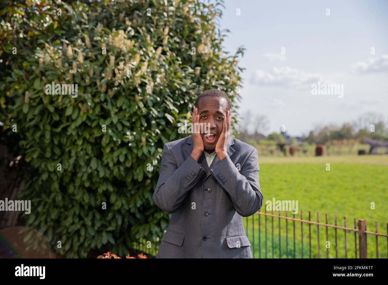 uomo d'affari preoccupato tocca il viso con le mani Foto Stock