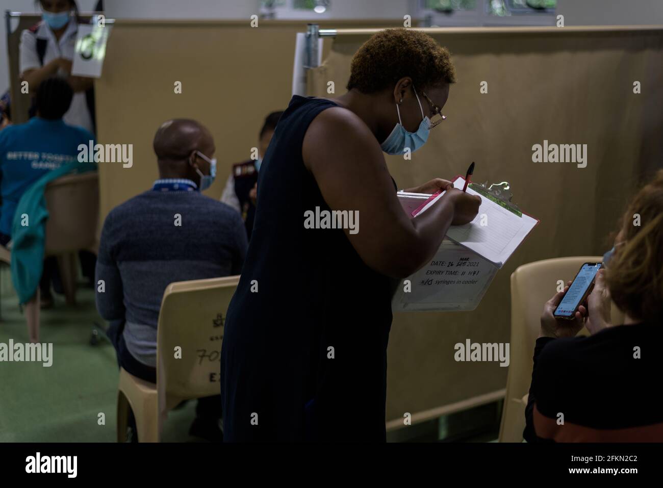 Un'infermiera controlla i dettagli della vaccinazione durante la clinica Sisonke del Sudafrica Sperimentazione vaccinale presso l'ospedale Groote Schuur di Città del Capo per la salute lavoratori Foto Stock